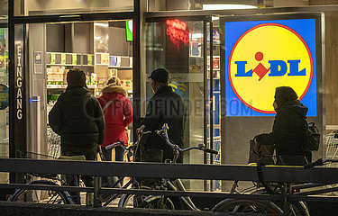 Lidl Supermarkt in München-Schwabing  Kunden warten kurz vor dem Eingang auf Einlass  maximale Zahl von Kunden im Laden automatisch erfasst  Januar 2022