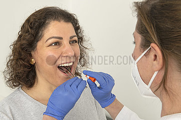 PCR-Test bei einer jungen Frau  Rachenabstrich in einer Arztpraxis  Planegg bei München  25. Januar 2022