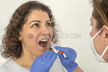 PCR-Test bei einer jungen Frau  Rachenabstrich in einer Arztpraxis  Planegg bei München  25. Januar 2022