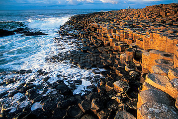Northern Ireland. Antrim county. Formed 40 million years ago  the Giant's Causeway is due to a basalt flow in a limestone valley which was covered by a layer of clay  a layer which cools it; as it cooled  the basalt burst into organ-like shapes. The legend says that it was the Irish giant Fionn Mac Cumhaill who threw stones into the sea to challenge his Scottish counterpart  Benandommer. The site has been on the UNESCO World Heritage List since 1986.