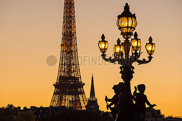 Frankreich  Paris (75) (7. Arrondissement). Pont Alexandre III Bridge Lamp Post Silhouette im Gegensatz zum Eiffelturm bei Sonnenuntergang