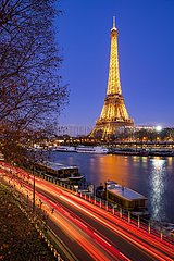 France  Paris  75007  75015 (7th and 15th arrondissement)  Grenelle. Eiffel Tower illuminated at twilight with the Seine River and car light trails on the Voie Georges-Pompidou