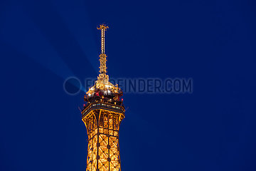 Frankreich  Paris  75007 (7. Arrondissement)  Champs de Mars. Die Spitze des Eiffelturms leuchtet in der Dämmerung