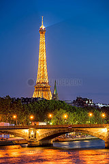 France  Paris  75007 (7th arrondissement)  Quai d'Orsay. The Eiffel Tower illuminated and Seine River banks in summer with Pont Alexandre III bridge at twilight