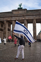 Berlin  Deutschland  Mann schwenkt eine israelische Flagge vor dem Brandenburger Tor im Bezirk Mitte