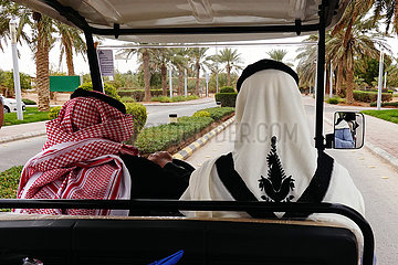 Riad  Saudi-Arabien  Einheimische Maenner sitzen in einem Elektro-Caddie