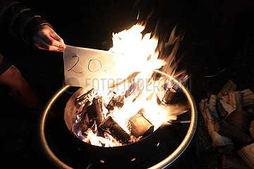 Berlin  Deutschland  Zettel mit der alten Jahreszahl wird an Silvester in einer Feuerschale verbrannt