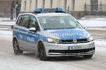 Berlin  Deutschland  Polizeiauto faehrt auf schneebedeckter Strasse