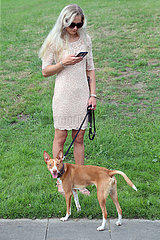 Hamburg  Deutschland  junge Frau mit Hund schaut auf ihr Mobiltelefon