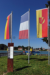 Plittersdorf  Deutschland  Fahne des Landkreis Rastatt sowie die Nationalfahnen der Bundesrepublik Deutschland und Frankreich an der Anlegestelle der Rheinfaehre
