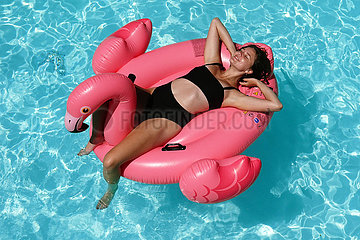 Bolsena  Italien  junge Frau liegt in einem Swimmingpool auf einer Luftmatratze