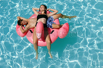 Bolsena  Italien  junges Paar liegt in einem Swimmingpool auf einer Luftmatratze