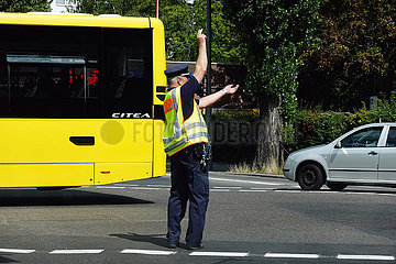 Berlin  Deutschland  Polizist auf einer Strassenkreuzung regelt den Verkehr