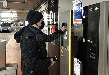 Berlin  Deutschland  Mann mit Mund-Nasen-Schutz bezahlt in einem Parkhaus sein Ticket an einem Automaten