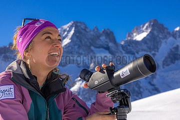 Frankreich. Hautes-Alpes (05) Nationalpark Ecrins  von der Spitze des Skigebiets von Serre Chevalier  Wildlife-Beobachtung mit einem Teleskop mit Rachel Bourg  Mid-Mountain-Guide  der dem mythischen Gipfel von La Meije an mehr als 2000 m über dem Meeresspiegel steht ' Höhe