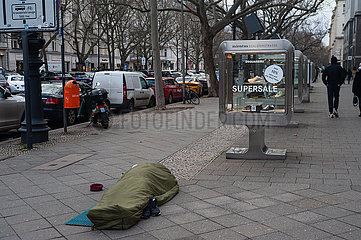 Berlin  Deutschland  Ein Obdachloser schlaeft auf dem Boden vor einem Geschaeft am Kurfuerstendamm