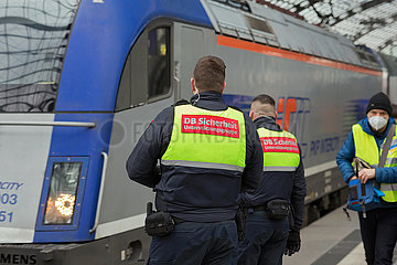 Berlin  Deutschland  DEU - Zwei Maenner des DB Sicherheitspersonals stehen am Hauptbahnhof am Gleis vor einem polnischen Zug