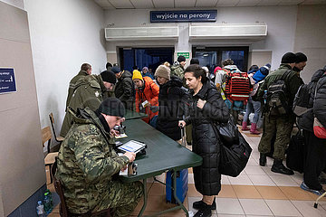 Polen  Chelm - Ukraine-Krieg: Ukrainischen Fluechtlingen erreichen den Bahnhof der Stadt nahe der polnisch-ukrainischen Grenze  polnischer Grenzer gibt Einreisestempel