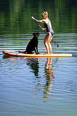 Schorfheide  Deutschland  Frau beim Stand-Up-Paddling mit Hund auf dem Weissen See