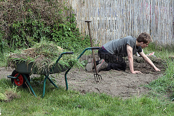 Berlin  Deutschland  junger Mann bei der Gartenarbeit