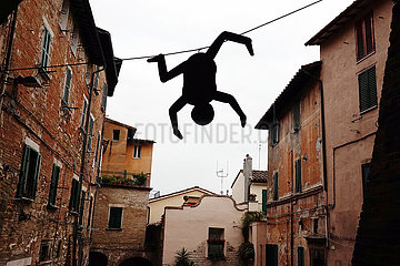 Perugia  Italien  Street-Art: Figur haengt kopfueber an einer Waescheleine