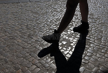 Berlin  Deutschland  Mensch wirft beim Gehen einen Schatten auf Kopfsteinpflaster