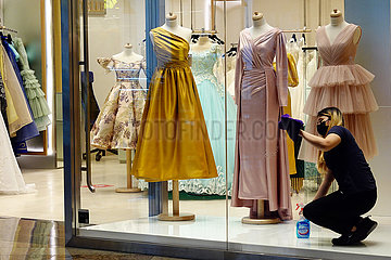 Dubai  Vereinigte Arabische Emirate  Verkaeuferin putzt wegen Kundenmangels in Zeiten der Coronapandemie die Schaufensterscheiben eines Modegeschaefts