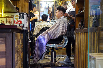 Hong Kong  China  Mann laesst sich von einem Friseur die Haare schneiden