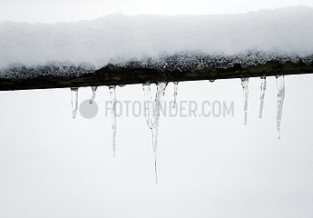 Graditz  Deutschland  Eiszapfen haengen an einem schneebedeckten Holzzaun