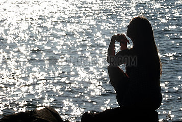 Bolsena  Italien  Silhouette: Frau sonnt sich am Ufer des Bolsena See