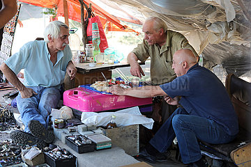Tiflis  Georgien  Maenner auf einem Flohmarkt beim Mittagessen