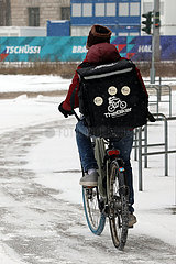 Berlin  Deutschland  Fahrer eines Lieferdienstes faehrt bei heftigem Schneefall auf einer Strasse