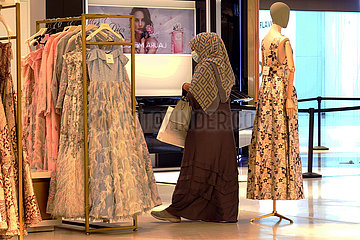 Dubai  Vereinigte Arabische Emirate  Frau schaut sich in einem Modegeschaeft ein Kleid an