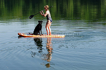 Schorfheide  Deutschland  Frau beim Stand-Up-Paddling mit Hund auf dem Weissen See