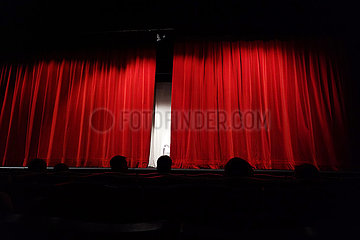 Berlin  Deutschland  Menschen sitzen in einem Theater vor einem fast geschlossenen Vorhang