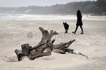 Ustka  Polen  Frau geht mit ihrem Hund am Strand spazieren