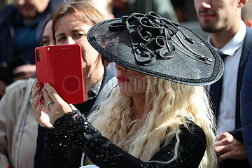 Paris  Frankreich  elegant gekleidete Frau mit Hut fotografiert mit ihrem Smartphone