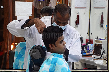 Doha  Katar  Jugendlicher laesst sich von einem Friseur die Haare schneiden