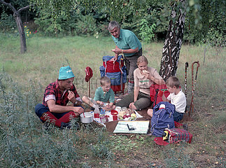 Potsdam  Deutsche Demokratische Republik  Familie macht bei einer Wanderung ein Picknick