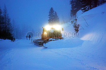 Obertraun  Oesterreich  Schneeraupe befreit eine Skipiste am Morgen vom Neuschnee