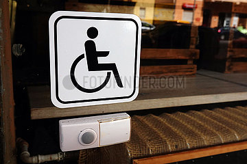 Berlin  Deutschland  Klingel fuer Rollstuhlfahrer an der Fensterscheibe eines Restaurants