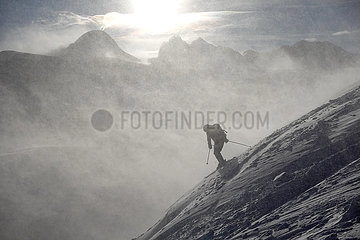 Obertraun  Oesterreich  Silhouette: Mann faehrt bei Schneefall Ski am Krippenstein