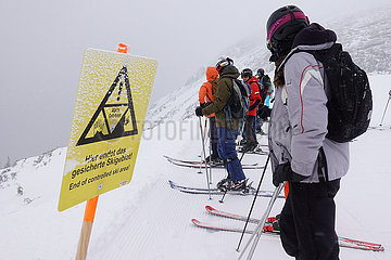 Obertraun  Oesterreich  Skifahrer stehen am Ende des gesicherten Skigebietes