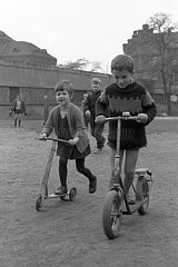 Ost-Berlin  Deutsche Demokratische Republik  Kinder fahren auf ihren Rollern eine Strasse entlang