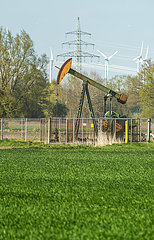 Deutschland  Barenburg - Erdoelproduktionsbohrung von Exxon Mobil mit einer Pferdekopfpumpe  hinten Windraeder und Strommast