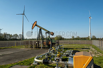 Deutschland  Barenburg - Erdoelproduktionsbohrung von Exxon Mobil mit einer Pferdekopfpumpe  hinten Windraeder