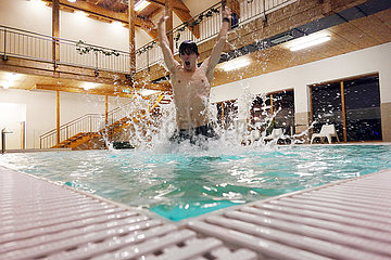 Obertraun  Oberoesterreich  Teenager tobt in einem Swimmingpool herum