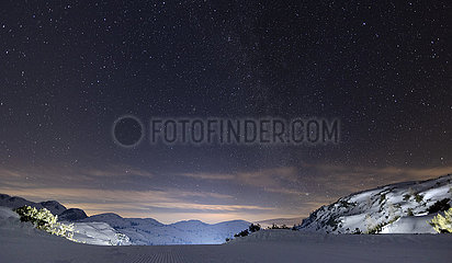 Obertraun  Oesterreich  Sternenhimmel leuchtet in der Nacht in den schneebedeckten Alpen