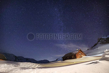 Obertraun  Oesterreich  Sternenhimmel leuchtet in der Nacht in den schneebedeckten Alpen