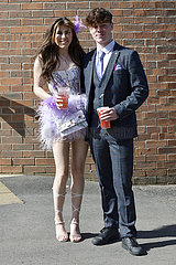 Aintree  Fashion on Ladies day: Young woman and his friend at the racecourse